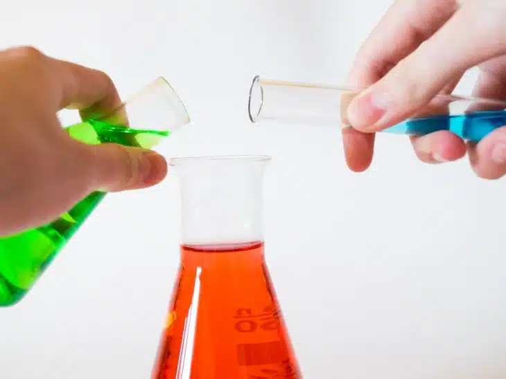 person holding laboratory flasks